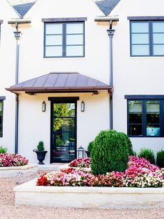 a white house with flowers in front of it