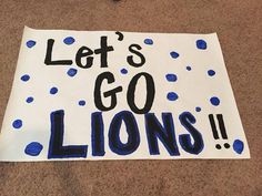 a sign that says let's go lions on the floor next to a pair of scissors