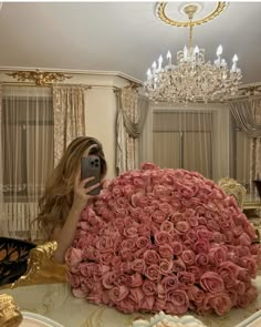 a woman taking a selfie in front of a large bouquet of roses