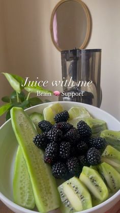 a white bowl filled with sliced up kiwis and blackberries