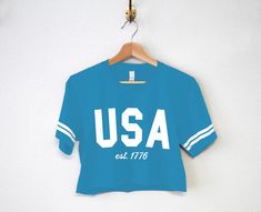 LOW SUPPLY FLASH SALE!! Only 5 of each size available, then they are gone! Pick Between "USA est. 1777", "America", or "Cheers Merica" USA est. 1776 Patriotic 4th of July Crop Top Shirts for women The perfect shirts for any Independence day party! Shirt Colors Available: Aqua blue with White Stripes Women's Sizes Available: S, M, L These run true to size. We recommend sticking with your normal shirt size, unless you are in between sizes or prefer a looser fit then order a size up. America Shirts, 4th Of July Shirts, Usa Patriotic, Cropped Tops, Crop Top Shirts, Cropped Tube Top, Shirts For Women, Perfect Shirt, Flash Sale