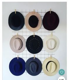 several hats are hanging on the wall with clothes pins attached to them and there is no image here