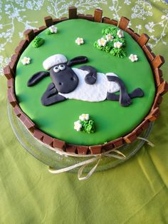 a cake that is decorated to look like a sheep laying down on the green ground