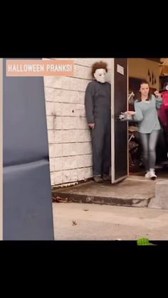 two people in masks are entering a building with their hands out to someone standing on the door