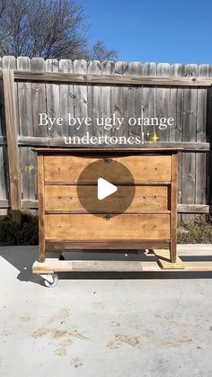 a wooden dresser sitting in front of a fence with the words bye bye tidy orange undertones on it