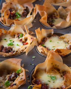 several mini pizzas with meat and cheese in them