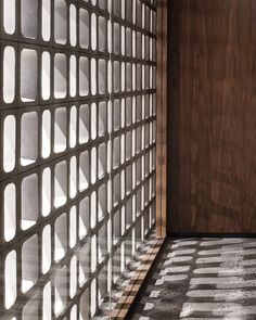 the wall is made up of small squares and wooden panels, with light shining through them