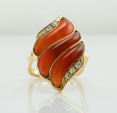 Fire Ring, Flame Ring, Orange Ring, Carnelian Ring, Diamond Ring, Vintage Ring, Gold Ring, Square Band, Gold Band, Cocktail Ring. This one of a kind estate ring is crafted in solid 18K Yellow Gold. The setting with natural Carnelian is reminiscent of flames. Absolutely stunning! Six diamonds total .13 carat of VS1 clarity and H color. The square band is 17mm x 16mm inside, it is hard to know the size. We would say the size is around 7-7.25 and the ring can easily be resized. The top of the ring Luxury Carnelian Ring For Formal Occasions, Yellow Gold Carnelian Jewelry With Polished Finish, Heirloom Carnelian Yellow Gold Rings, Luxury Carnelian Ring Jewelry, Luxury Carnelian Ring, Elegant Carnelian Yellow Gold Rings, Elegant Carnelian Ring In Yellow Gold, Elegant Yellow Gold Carnelian Ring, Elegant Carnelian Rings With Polished Finish