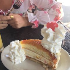 a piece of cake on a plate with whipped cream and a fork next to it