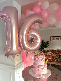 a birthday cake with pink frosting and balloons in the shape of the number six