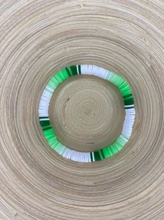 an overhead view of a circular wooden object with green and white toothbrushes in it