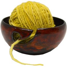 a ball of yellow yarn in a brown and red bowl on a white background,