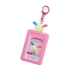 a pink keychain with a cartoon character on it's front and back