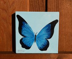 a blue butterfly painted on a wooden surface