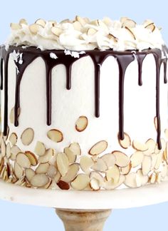 a white cake with chocolate drizzle and almonds