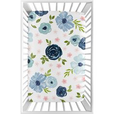 a white crib with blue and pink flowers on it