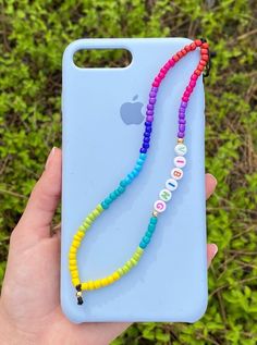 a person holding an iphone case with colorful beads on the back and a lanyard attached to it