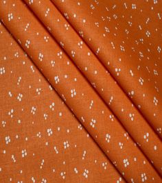 an orange fabric with white dots on it