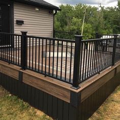 a wooden deck with black iron railings