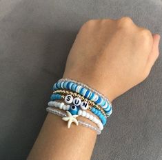 a woman's arm wearing bracelets with beads and charms on it, including an octopus