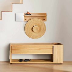 a hat is hanging on the wall next to a wooden shelf with shoes and a mirror