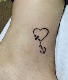 a small tattoo on the ankle of a woman with an arrow and heart shaped balloon