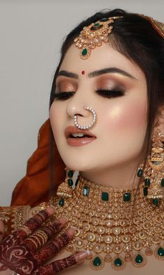 a woman with makeup and jewelry on her face