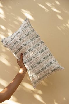 a person holding a pillow in their hand