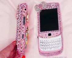 a pink cell phone with lots of swarong on it's back and sides