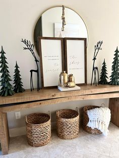 three baskets sitting on top of a wooden table next to a mirror and christmas decorations