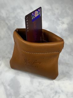 a brown leather wallet with a credit card in it's pocket on a marble surface