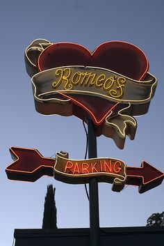 a sign for a parking lot with two hearts and arrows attached to it's sides