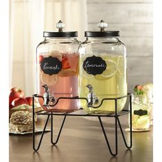 two glass jars filled with drinks sitting on top of a table