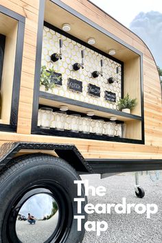 the back end of a truck with wine bottles in it's storage compartment and wheels