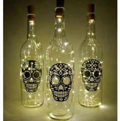 three bottles with lights in them that have skulls on them