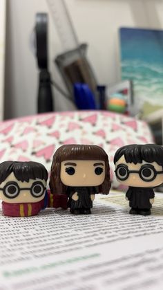 three harry potter figurines sitting on top of a bed next to each other