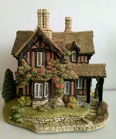 a figurine of a house with flowers on it