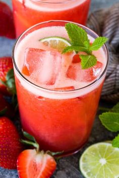 two glasses filled with watermelon and limeade next to strawberries on a table