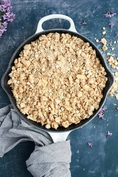 a skillet filled with oatmeal sitting on top of a blue table