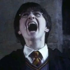 a young man with his mouth open and wearing a harry potter tie in front of him