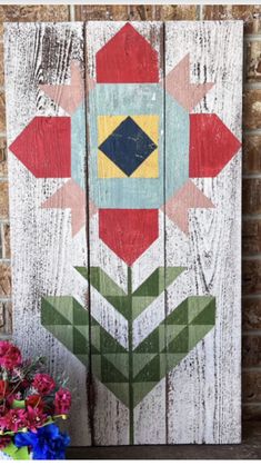 a wooden sign with flowers painted on it