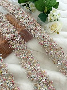 two pieces of beaded fabric with flowers in the background