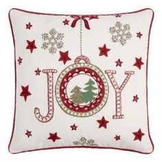 a christmas pillow with the word joy hanging from it's center and stars around it