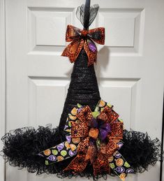 a halloween tree made out of mesh and candy canes is hanging on the front door