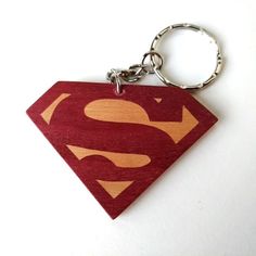 a wooden keychain with a superman symbol on it