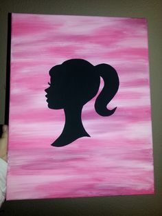 the silhouette of a woman's head is painted on pink and black canvases