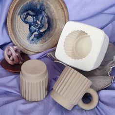 some pottery is laying on a purple blanket