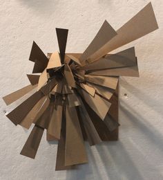 a clock made out of brown paper on the wall