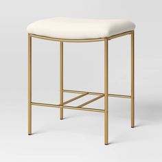 a gold stool with a white seat