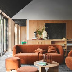 a living room with orange couches and chairs